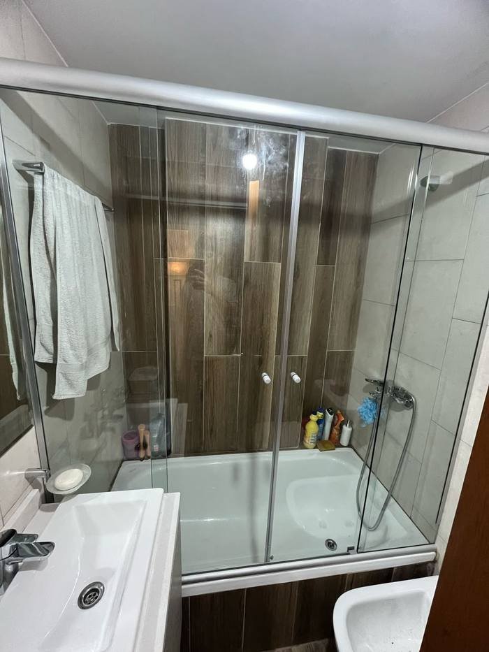 Mampara plateada en baño madera